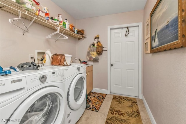 washroom with separate washer and dryer, light tile patterned floors, and cabinets