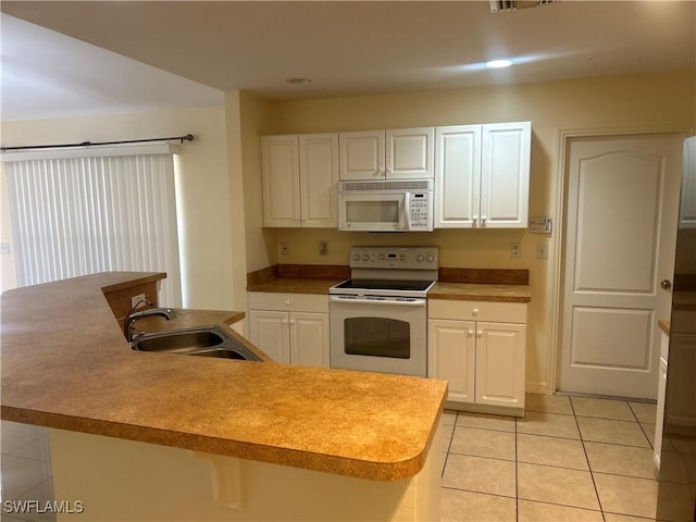 kitchen featuring an island with sink, sink, white cabinets, light tile patterned floors, and white appliances