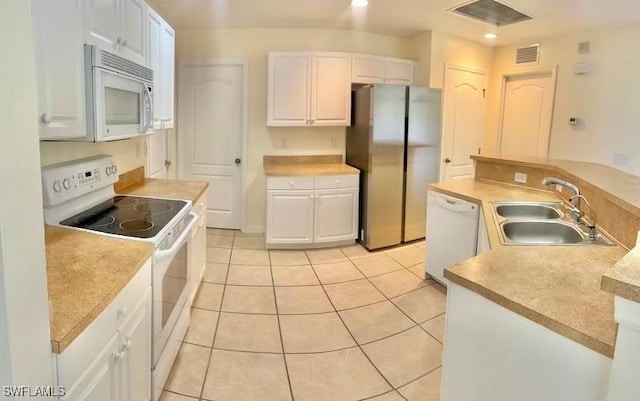 kitchen featuring white cabinetry, sink, white appliances, and light tile patterned floors