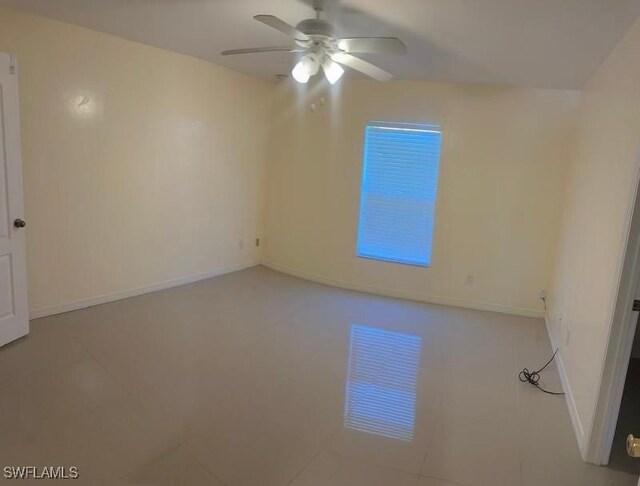 spare room with ceiling fan and light tile patterned floors