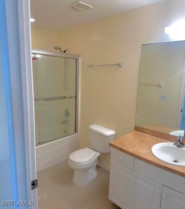 full bathroom featuring enclosed tub / shower combo, vanity, toilet, and tile patterned flooring