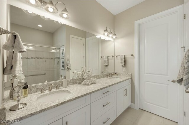 bathroom with tile patterned floors, a shower with shower door, and vanity