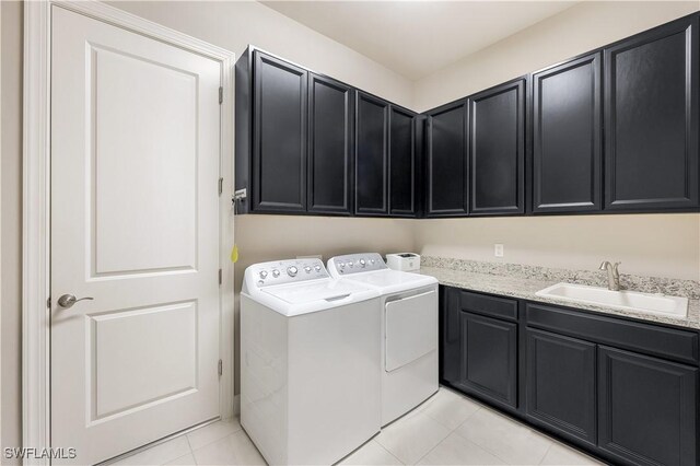 laundry room with independent washer and dryer, cabinets, sink, and light tile patterned floors