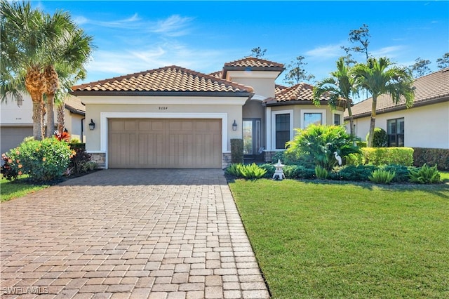 mediterranean / spanish house with a garage and a front lawn