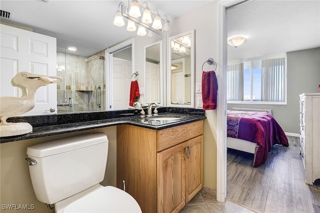 bathroom with vanity, toilet, and a shower with shower door