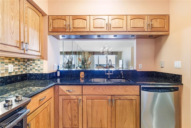 kitchen with appliances with stainless steel finishes, sink, decorative backsplash, and dark stone counters