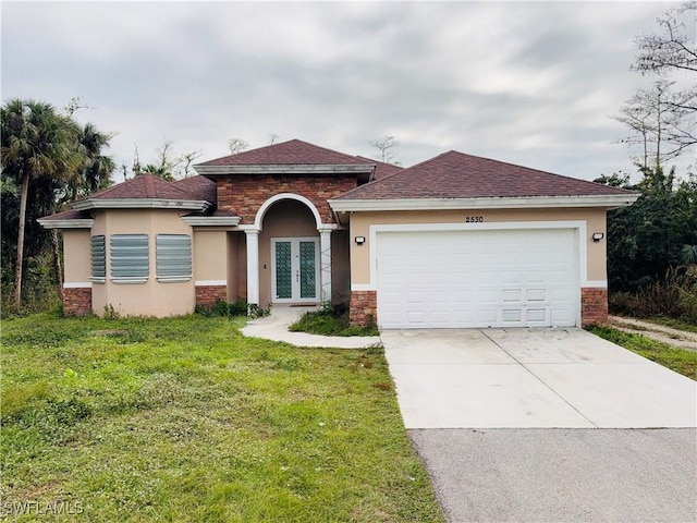 view of front of home with a garage, a front lawn, and french doors