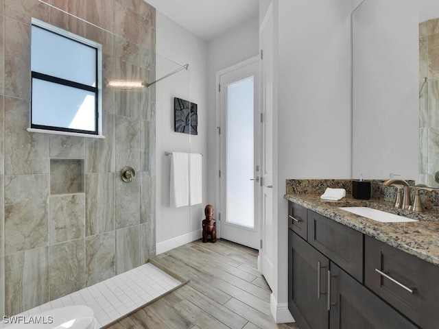 bathroom with vanity, tiled shower, and hardwood / wood-style floors