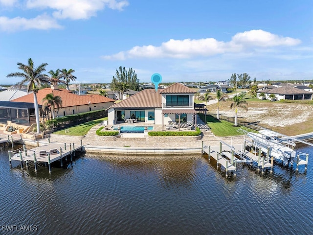 rear view of property featuring a swimming pool, a patio area, and a water view