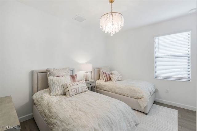 bedroom featuring hardwood / wood-style flooring and a chandelier