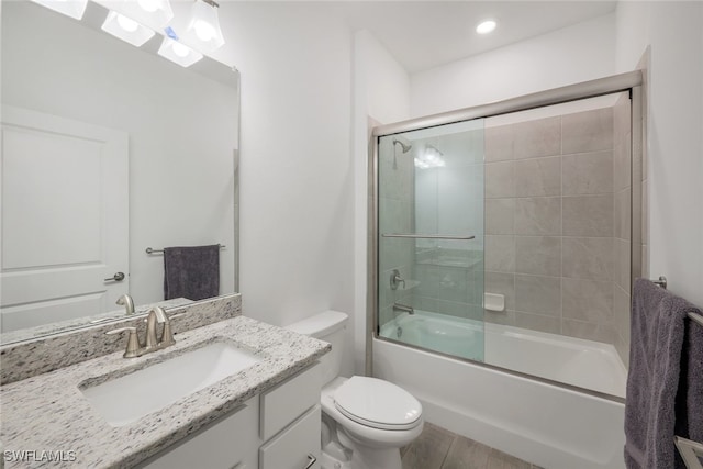 full bathroom featuring bath / shower combo with glass door, vanity, and toilet