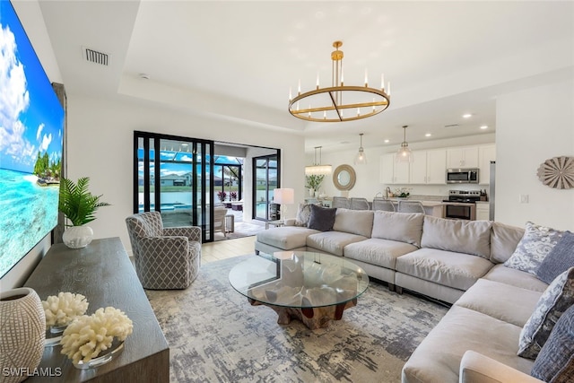 living room featuring a raised ceiling and a notable chandelier