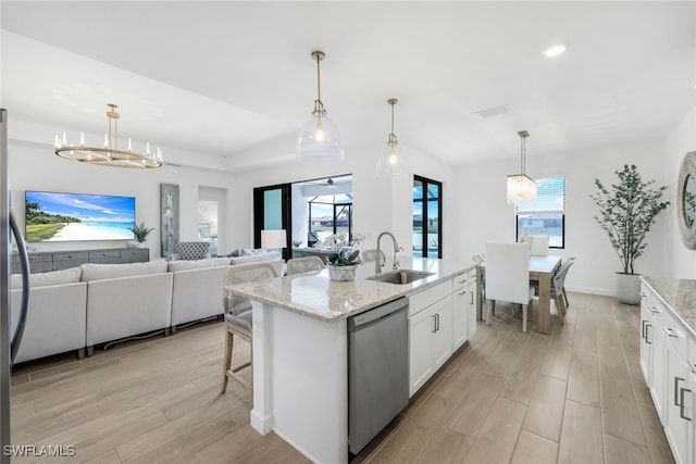 kitchen with dishwasher, a kitchen island with sink, white cabinets, and decorative light fixtures