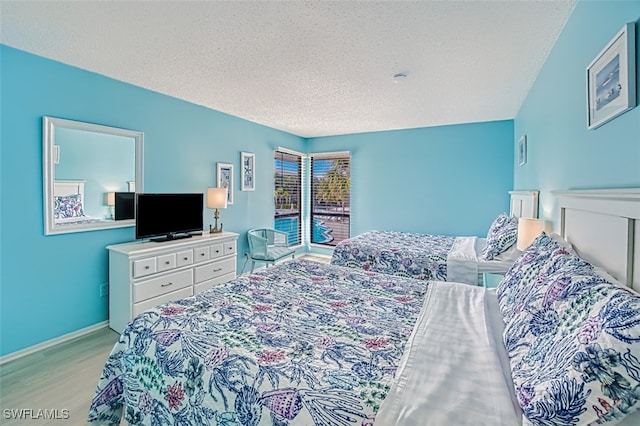 bedroom featuring light hardwood / wood-style floors and a textured ceiling