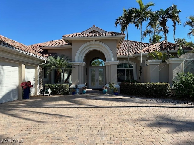 mediterranean / spanish-style home featuring french doors and a garage