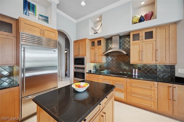 kitchen with wall chimney range hood, ornamental molding, black appliances, a kitchen island, and decorative backsplash