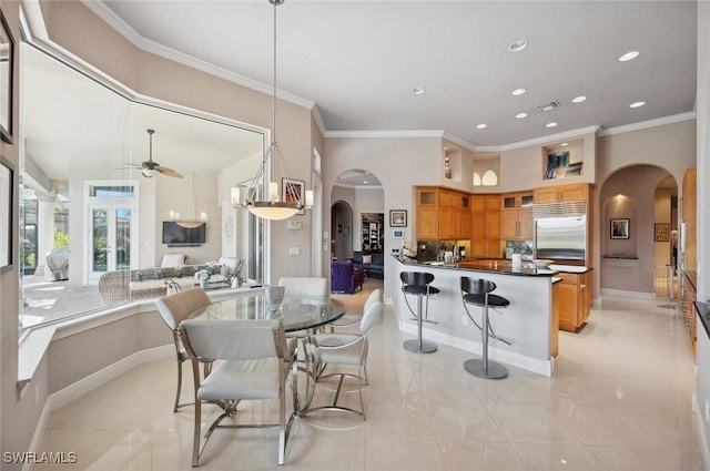 dining space with light tile patterned floors, ornamental molding, and ceiling fan