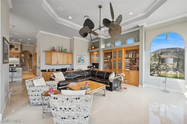 living room with crown molding, ceiling fan, and a raised ceiling