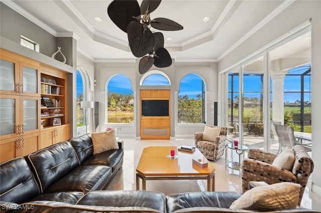 sunroom with ceiling fan and a raised ceiling