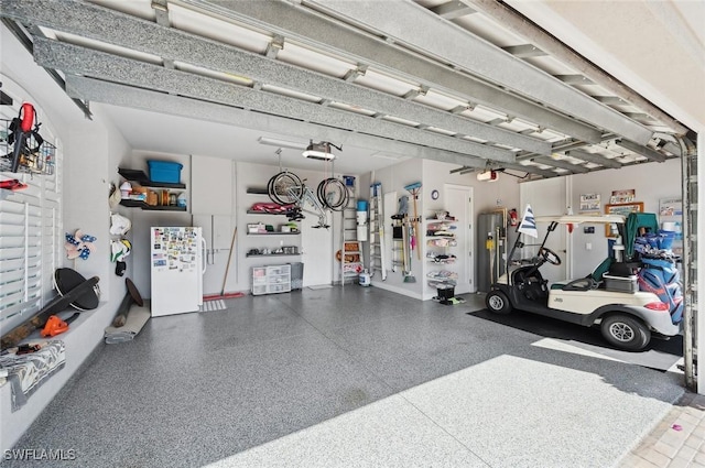 garage with a garage door opener, white fridge, and gas water heater