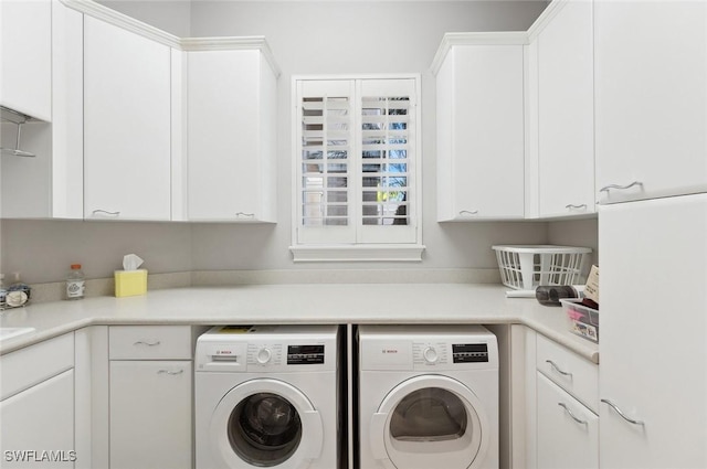 laundry area with cabinets and washing machine and clothes dryer