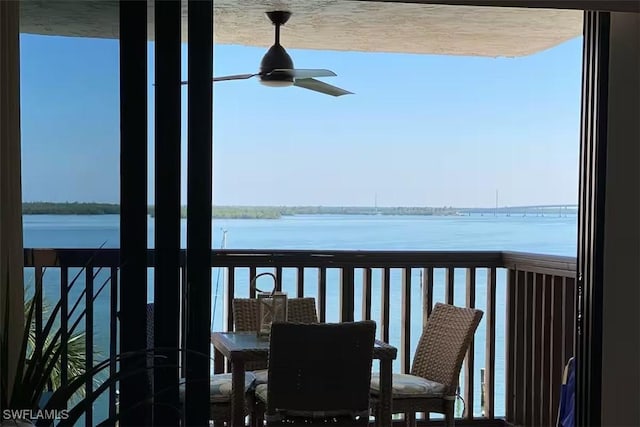 balcony featuring a water view and ceiling fan