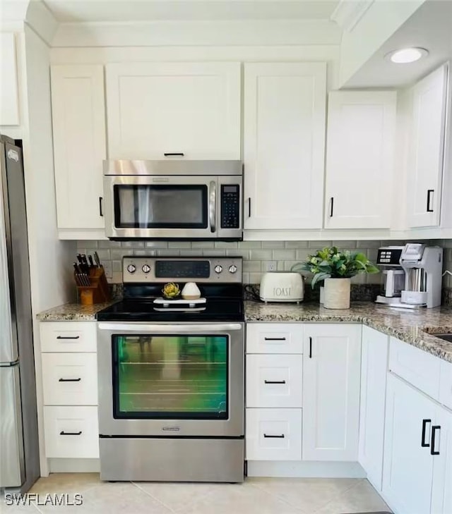 kitchen with white cabinetry, appliances with stainless steel finishes, and stone counters