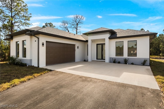 prairie-style house featuring a garage and a front yard