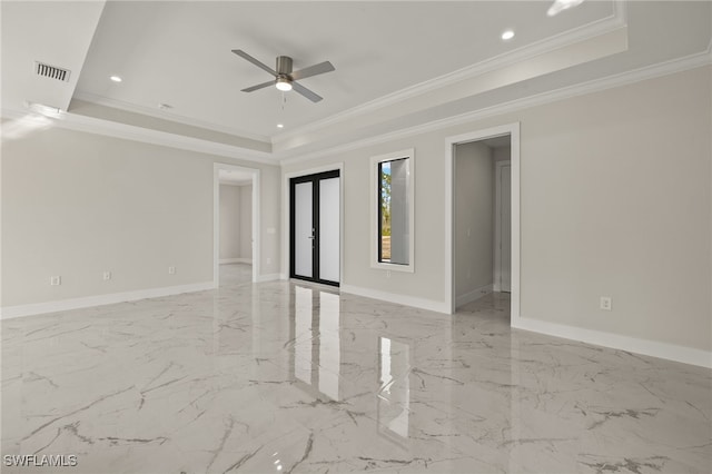 empty room with a tray ceiling, ornamental molding, and ceiling fan