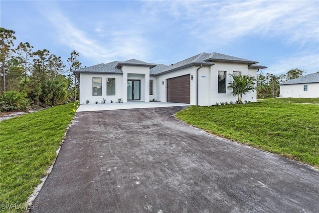 view of front of property with a garage and a front lawn