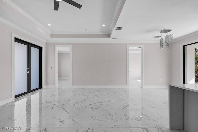 empty room featuring a raised ceiling, crown molding, ceiling fan, and french doors