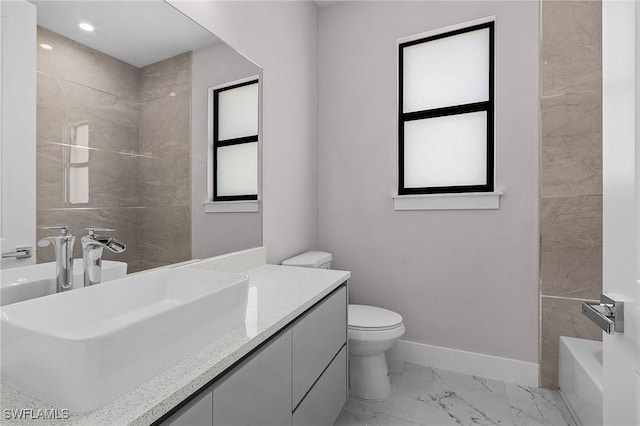 full bathroom featuring vanity, tiled shower / bath, and toilet