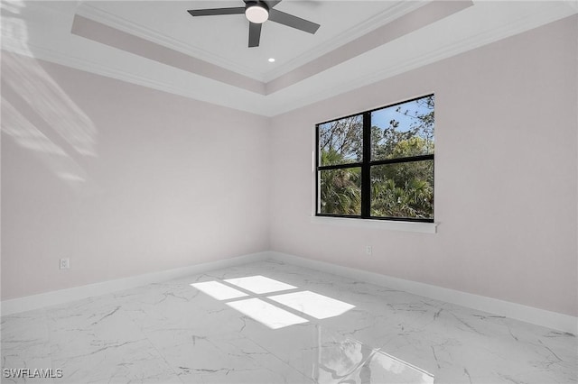 empty room featuring crown molding, ceiling fan, and a tray ceiling