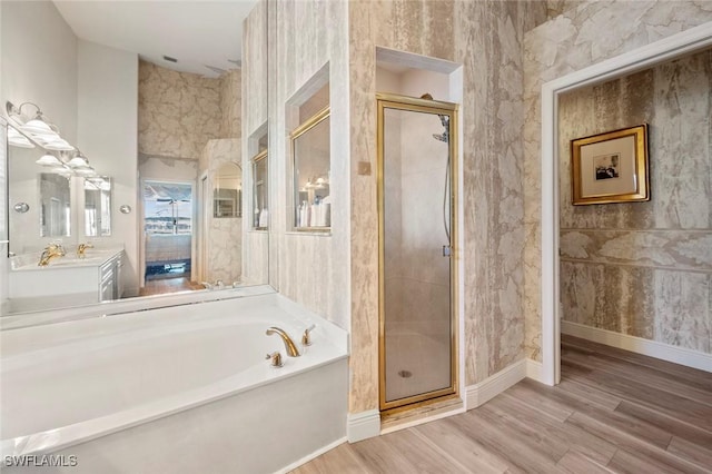 full bathroom with a garden tub, a shower stall, and wood finished floors