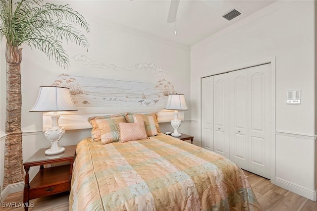 bedroom featuring crown molding, light hardwood / wood-style flooring, a closet, and ceiling fan