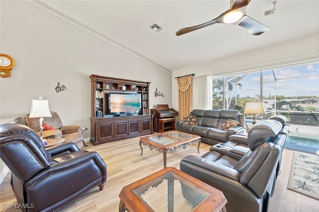 living room featuring vaulted ceiling, ceiling fan, and light wood-type flooring