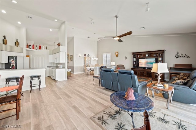 living room featuring ceiling fan, high vaulted ceiling, and light hardwood / wood-style flooring