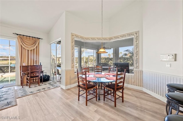 dining area featuring a healthy amount of sunlight, wainscoting, and wood finished floors