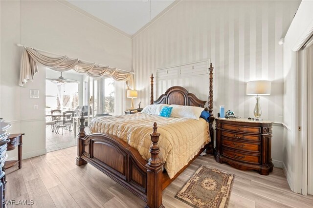 bedroom with light hardwood / wood-style flooring, access to outside, and high vaulted ceiling