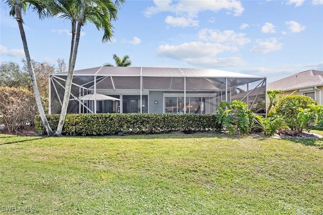 back of property featuring glass enclosure and a lawn