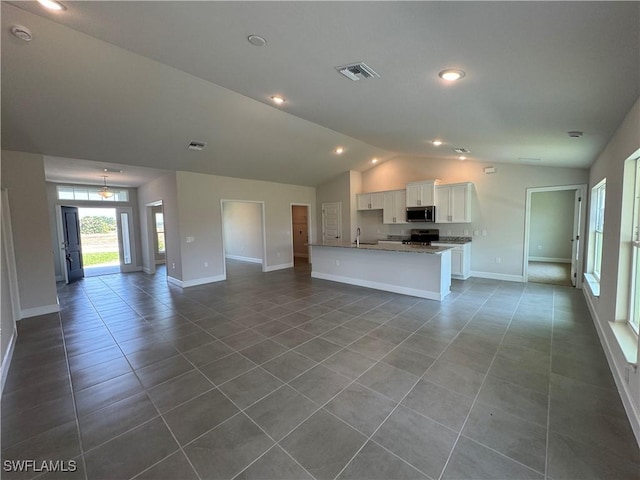 kitchen with white cabinets, stainless steel appliances, open floor plan, lofted ceiling, and visible vents