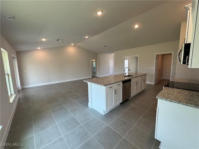 kitchen featuring vaulted ceiling, a sink, white cabinets, stainless steel appliances, and light tile patterned flooring