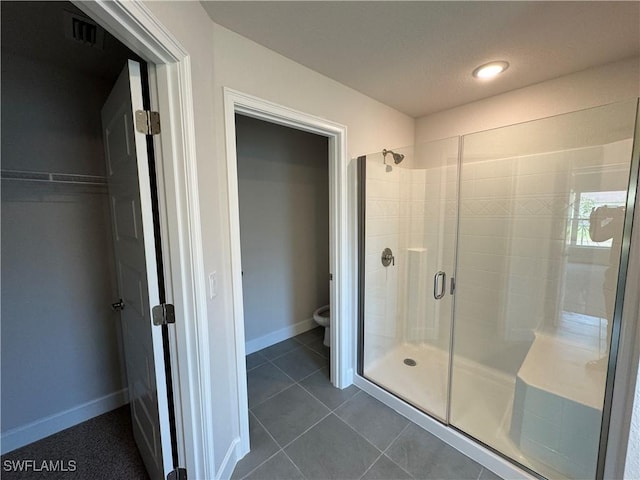 full bath with visible vents, tile patterned flooring, a shower stall, baseboards, and toilet