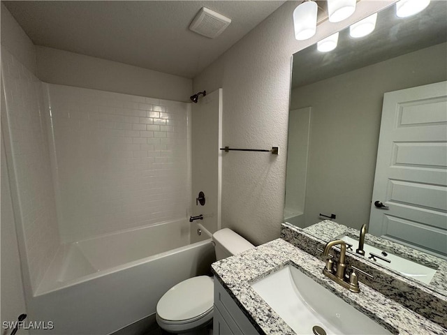 bathroom featuring visible vents, vanity, a textured wall, toilet, and bathtub / shower combination