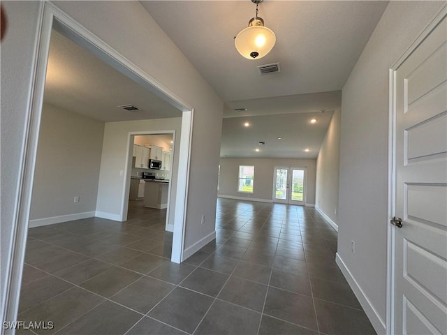 interior space with dark tile patterned floors, baseboards, recessed lighting, and visible vents