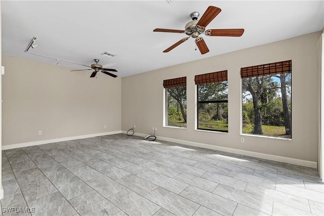 empty room with rail lighting and ceiling fan