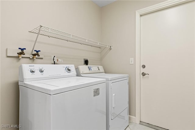 laundry room with light tile patterned floors and washing machine and clothes dryer