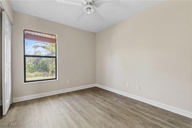 empty room with hardwood / wood-style floors and ceiling fan