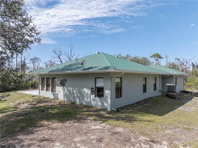 view of property exterior featuring central AC and a yard