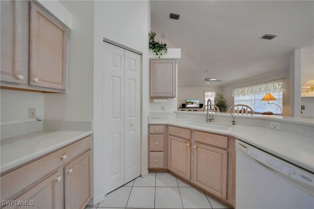 kitchen with white dishwasher, sink, and light brown cabinets